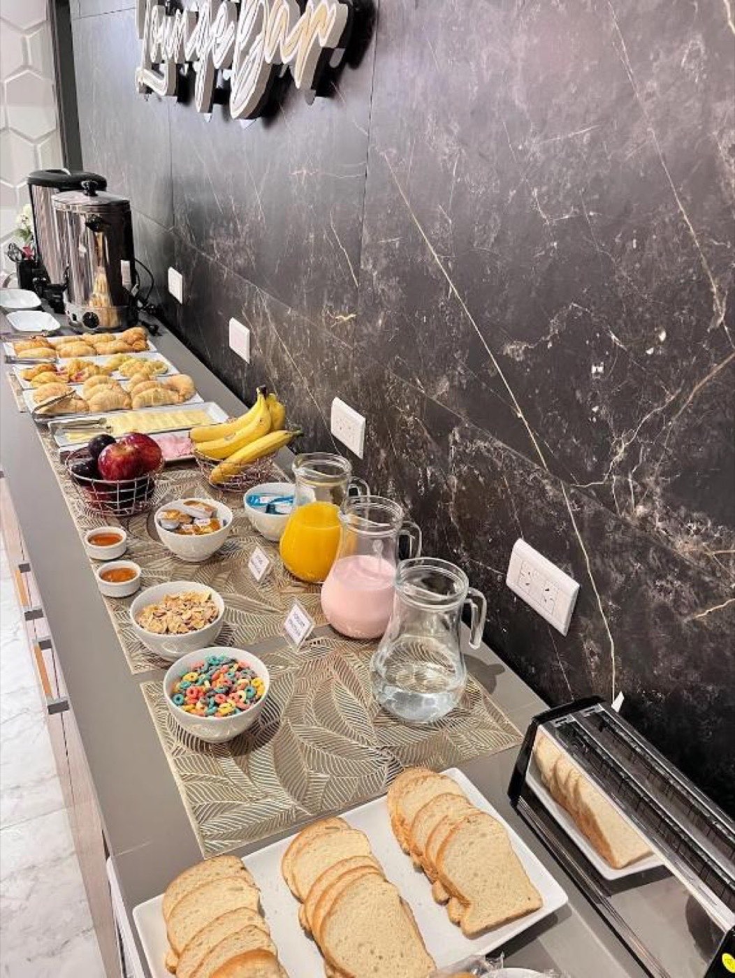 Buffet de desayuno con facturas, frutas y jugos