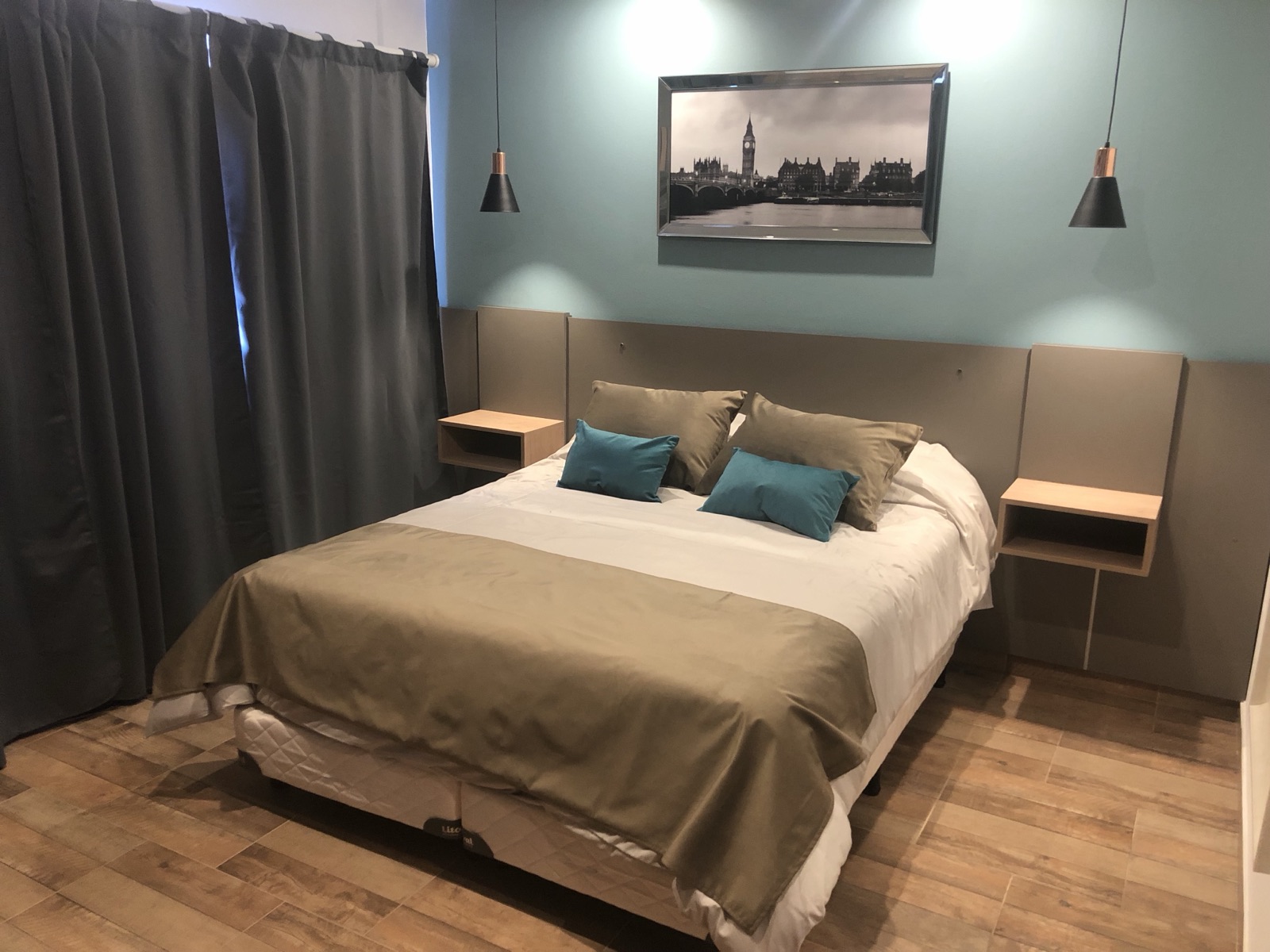 Habitación matrimonial con cama queen y pared celeste